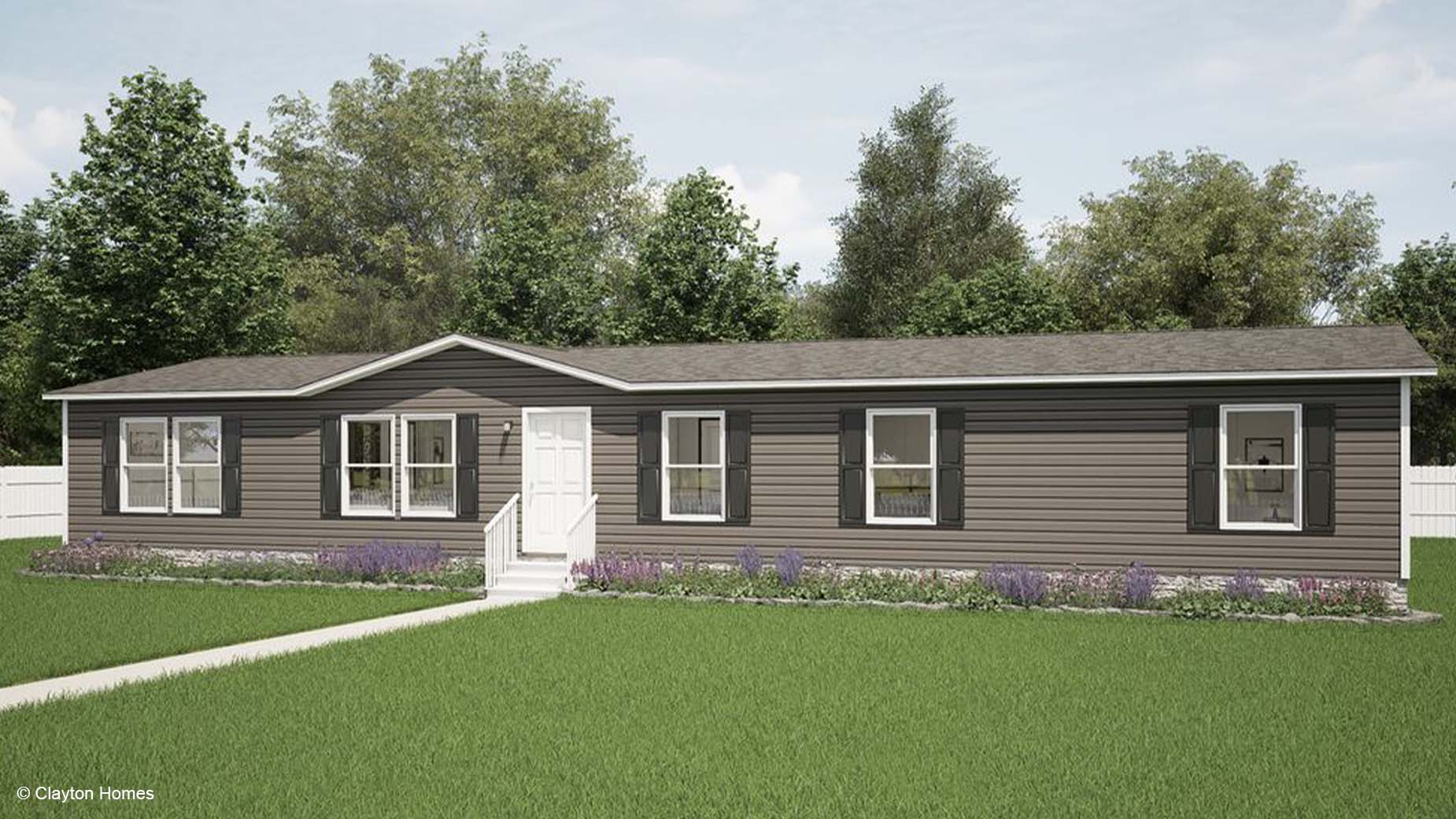 Charming single-story manufactured home with white trim, six windows, and a front door, all surrounded by a lush green lawn.