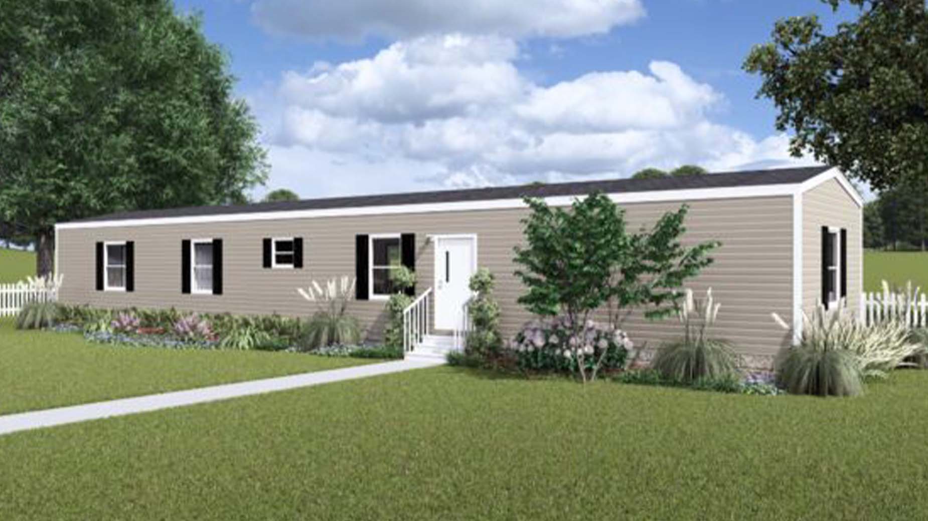 A beige manufactured home with white trim sits amid a green lawn, lush plants, and a charming white picket fence.