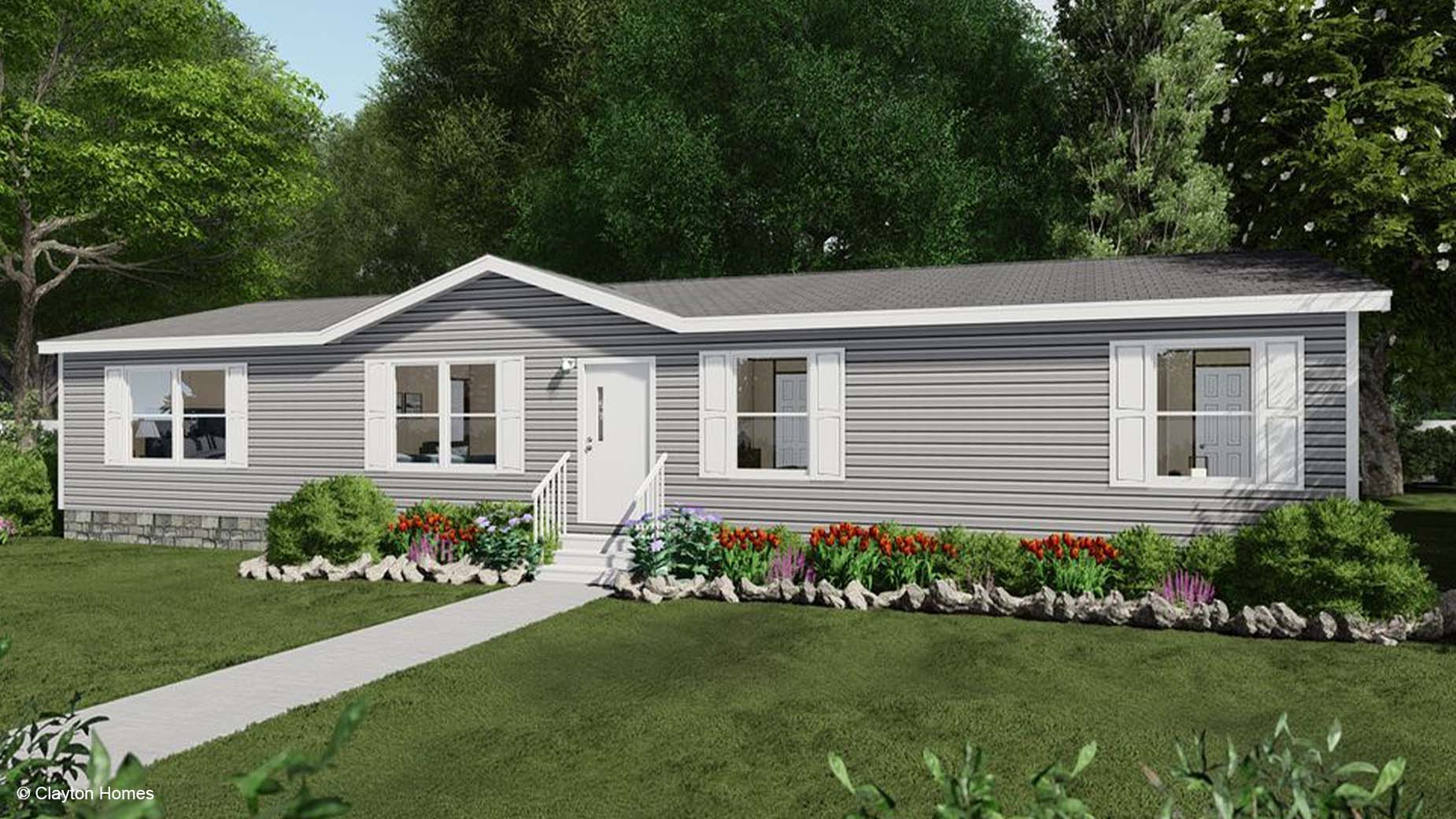Charming single-story gray manufactured home with white trim, inviting front steps, and a garden filled with vibrant red and white flowers.