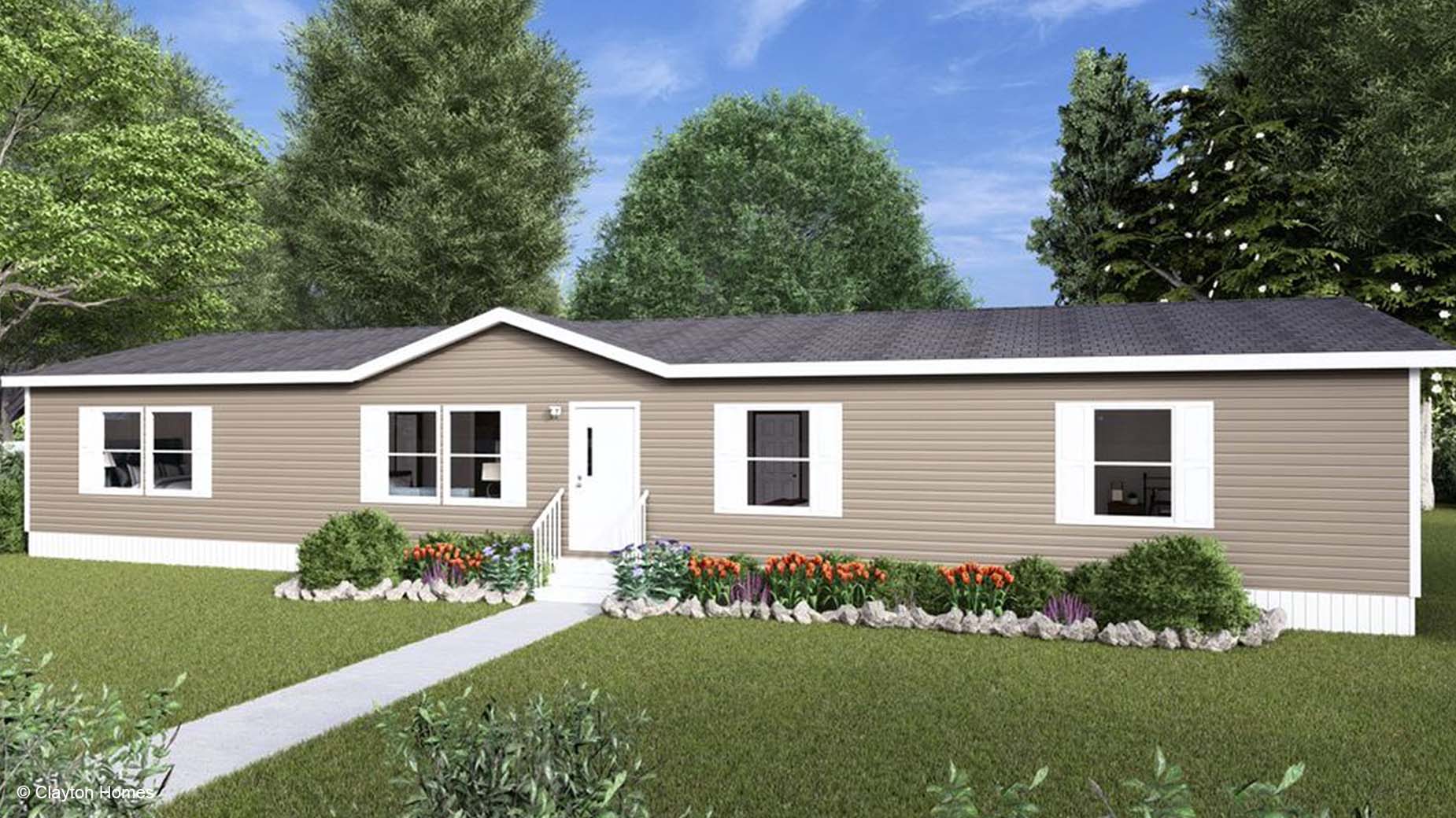 A tan manufactured home with white trim, a cozy front porch, and colorful landscaping sits in a grassy yard.